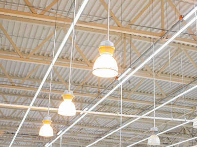 Ceiling with bright lamps in a modern warehouse. Image of bright light, a large space for trade, storage, commercial activity.